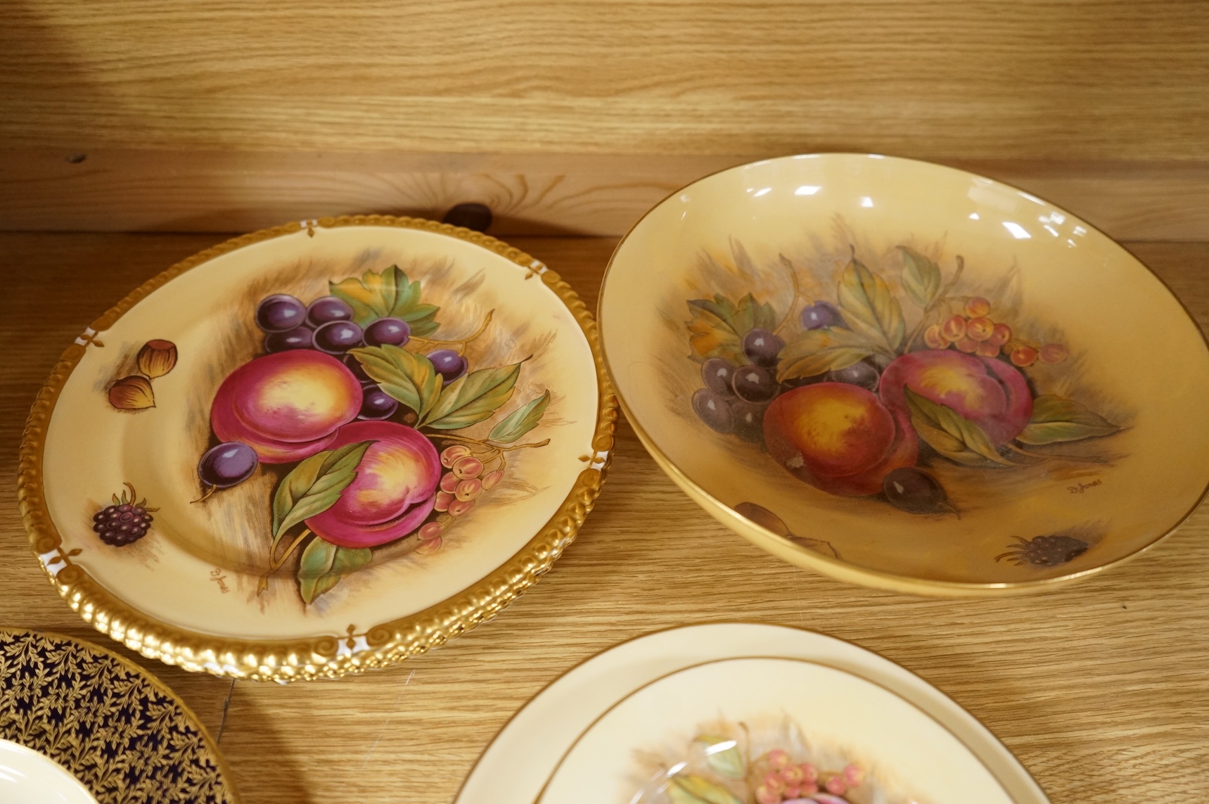 A collection of Aynsley ‘Orchard Gold’ fruit-painted tea/dinner wares and vases, largely signed by D Jones, largest 26cm in diameter